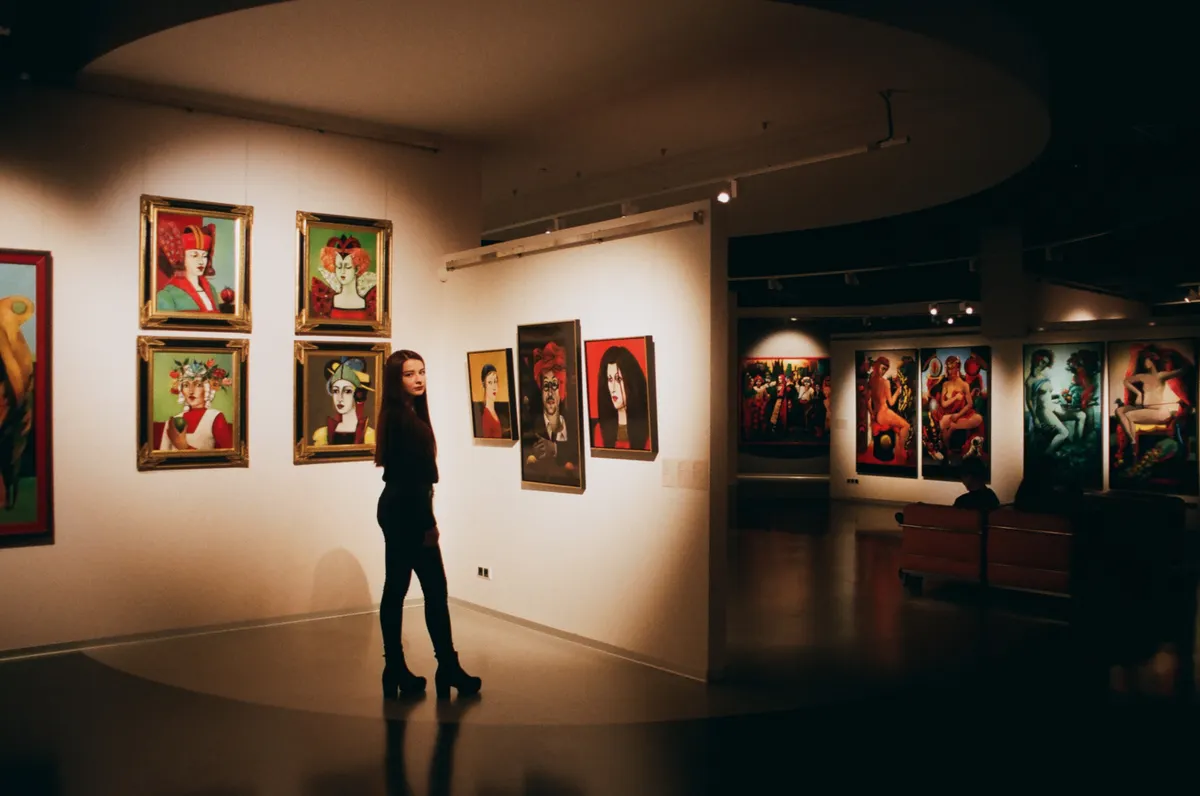 Person zwischen Gemälden in einer Galerie