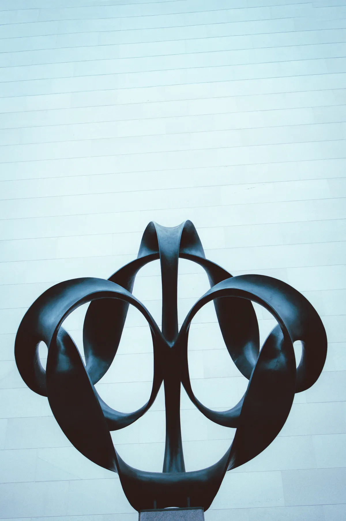 Abstrakte Skulptur vor einer minimalistischen Wand