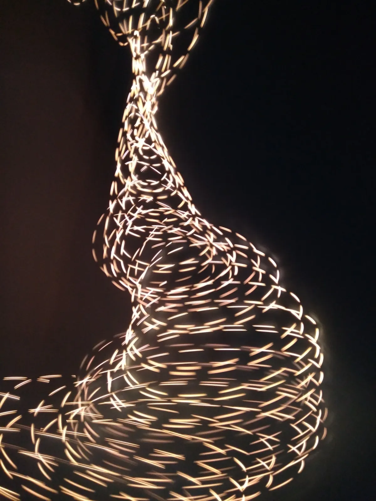 Spiralförmige Lichtinstallation vor dunklem Hintergrund